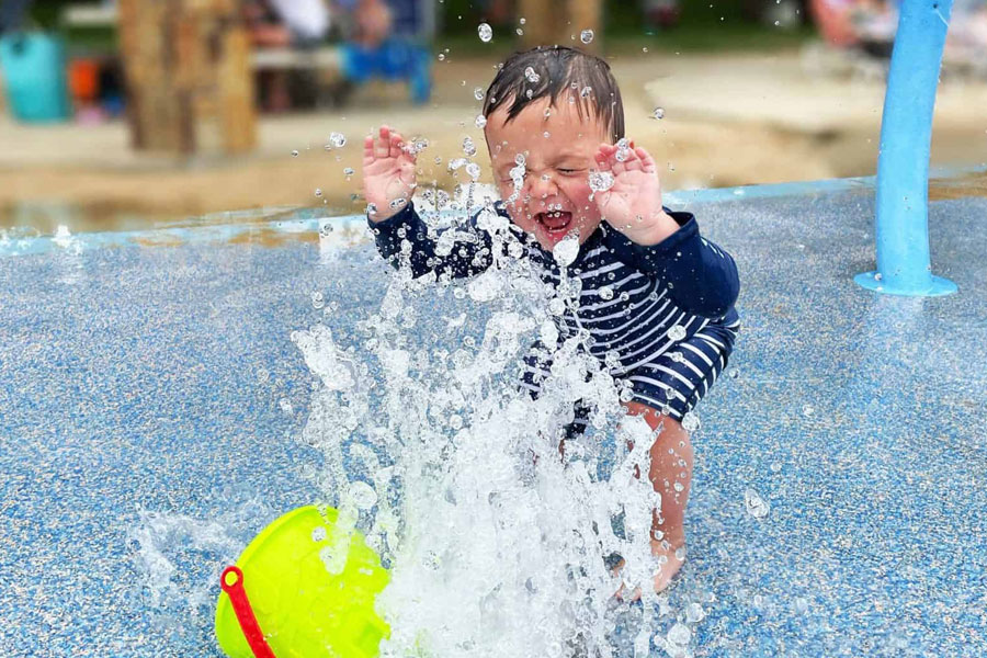Child resident of SRCA playing in community splash pad